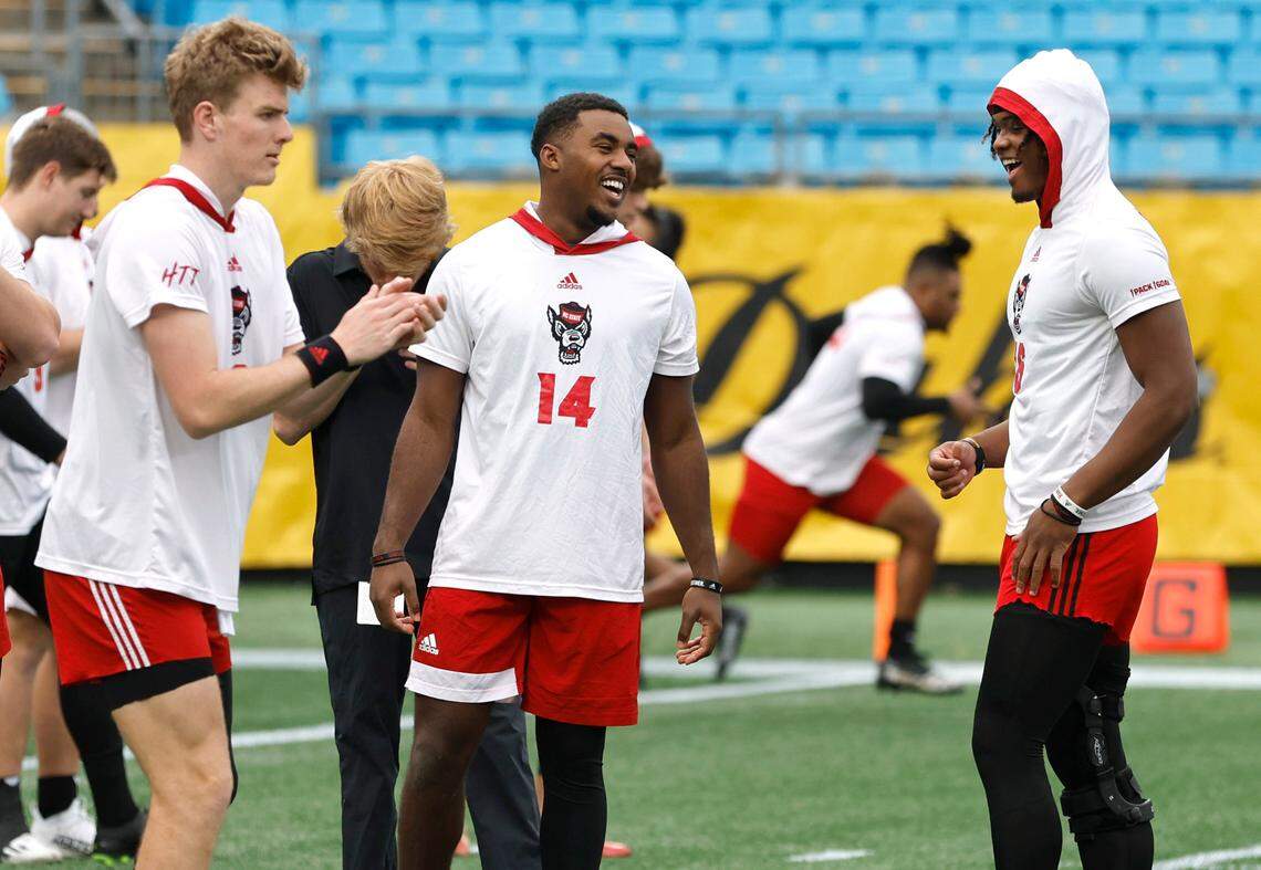 N.C. State quarterback Jack Chambers (14), center, laighs with quarterback MJ Morris (16) as they warm up with quarterback Ben Finley (10) before the Wolfpack’s game against Maryland in the Duke’s Mayo Bowl at Bank of America Stadium in Charlotte, N.C., Friday, Dec. 30, 2022.