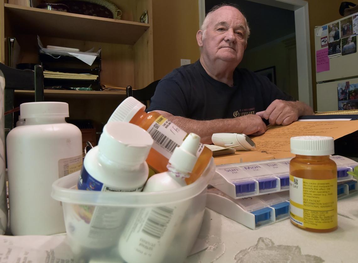 Frank Marshall with a pile of medicines he takes every day at his home.