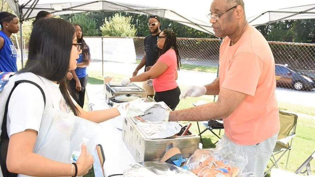 The pandemic-born pop-up hot dog stand QueDogs will open a brick and mortar location in Durham’s Lakewood neighborhod. The brand is owned by brother and sister Patrick Johnson and Kathryn Johnson Thompson, center, and their father Harold Johnson, right.