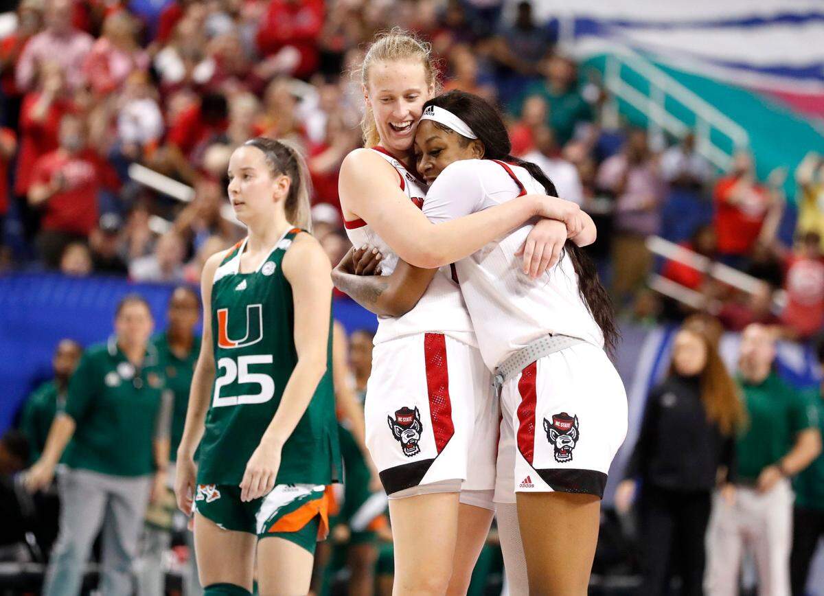 N.C. State’s Elissa Cunane (33) and Jada Boyd (5) hug as time runs out in the game to win the ACC womens basketball tournament in Greensboro, N.C., Sunday, March 6, 2022. Miamis Karla Erjavec (25) is to the left.