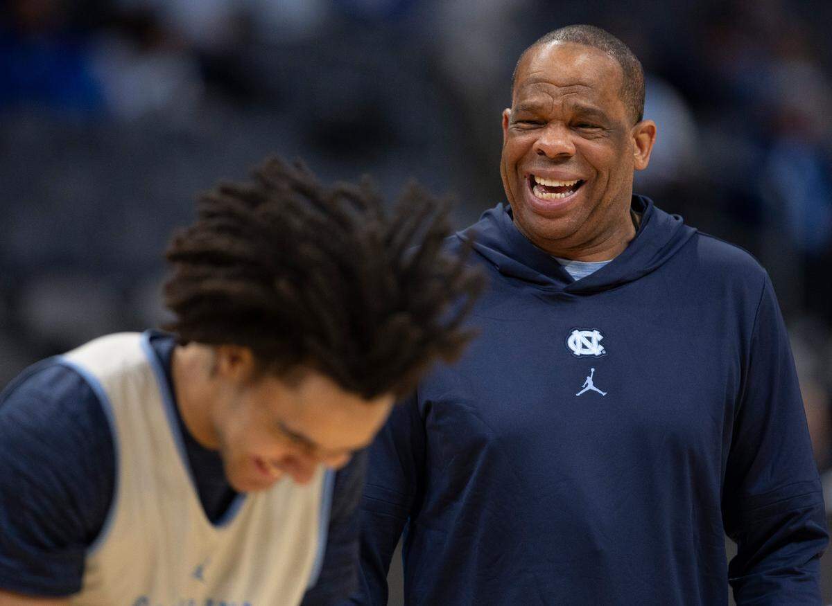 North Carolina’s Elliot Cadeau (2) has a fun exchange with coach Hubert Davis during their practice on Wednesday, March 20, 2024 as they prepare for the NCAA Tournament at Spectrum Center in Charlotte, N.C.