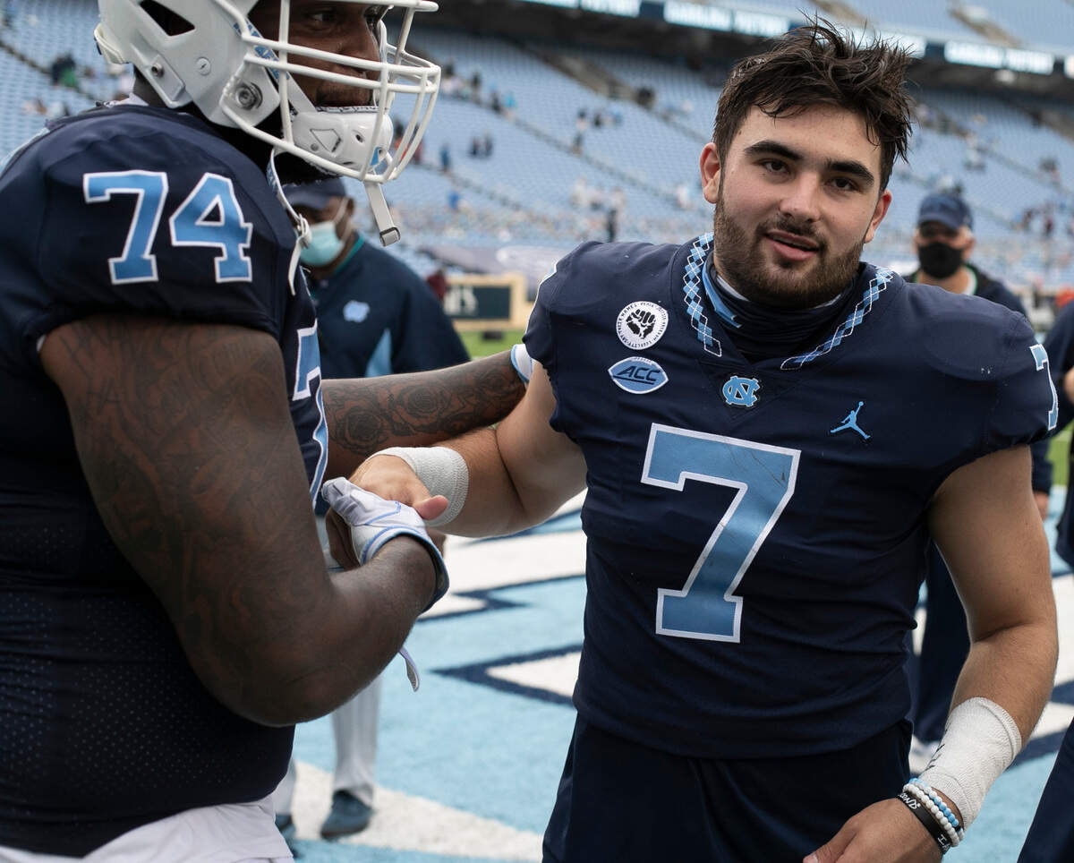 North Carolina’s Jordan Tucker (74) embraces quarterback Sam Howell (7) following their 56-49 victory over Virginia Tech on Saturday, October 10, 2020 at Kenan Stadium in Chapel Hill, N.C. Howell passed for 257 yards and three touchdowns.