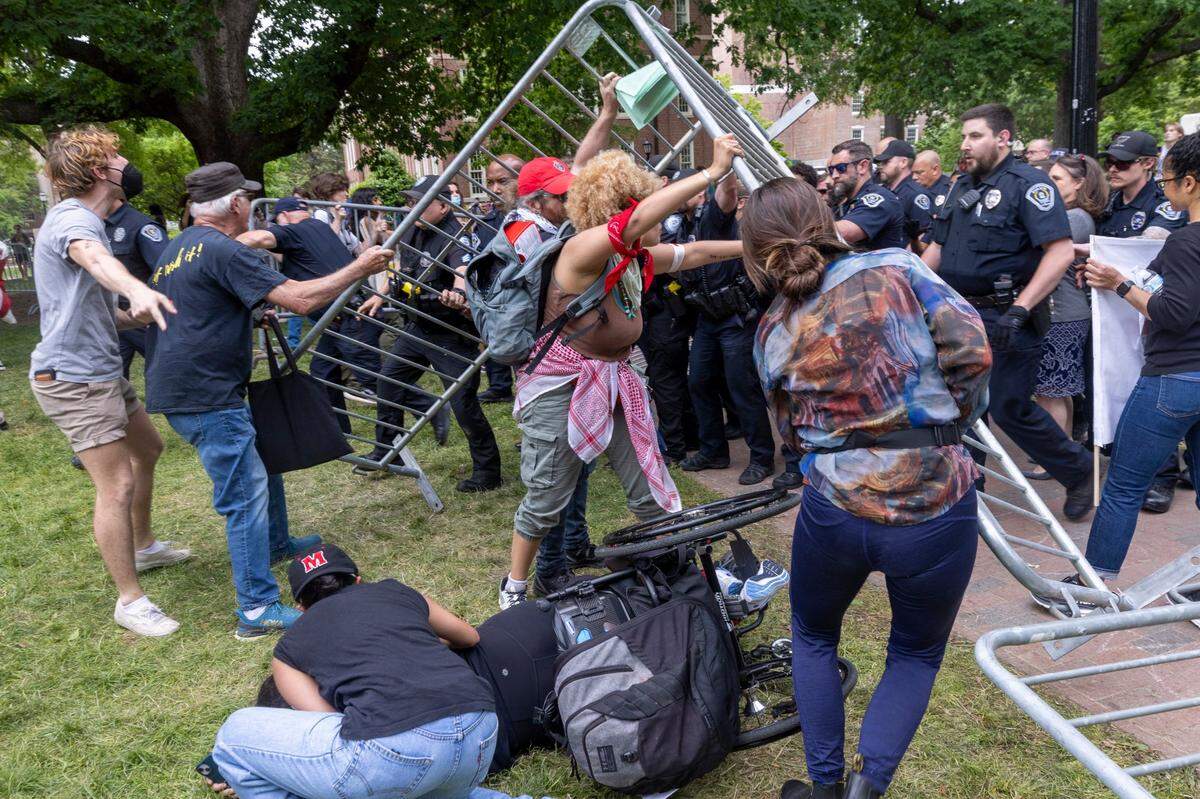 People try to aid Laura Saavedra Forero after she was knocked from a wheelchair as demonstrators clashed with police after replacing an American flag with a Palestinian flag Tuesday, April 30, 2024 at UNC-Chapel Hill. Police removed a “Gaza solidarity encampment” earlier Tuesday morning.