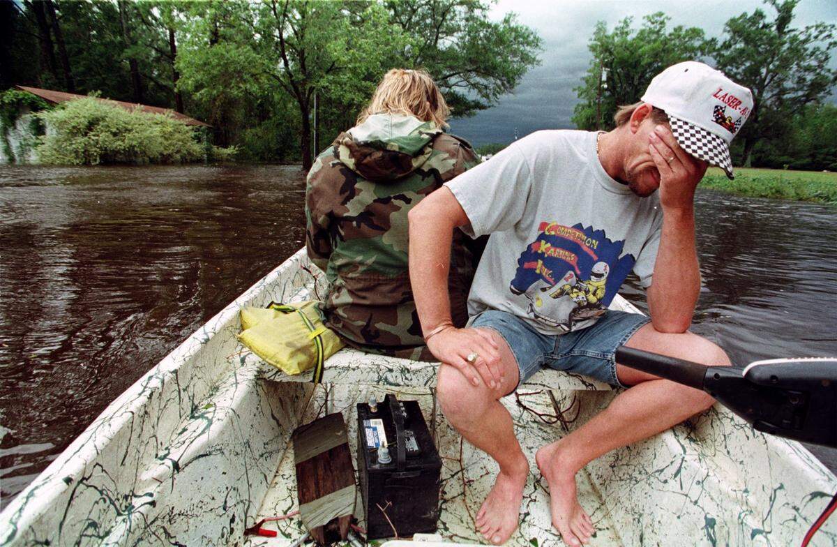 An exhausted Tony Townsend rests his head in his hand while riding on a friend’s boat through a flooded area to check on his mother near Vanceboro. She had stayed in her home throughout Hurricane Floyd, but floodwaters were at her doorstep Townsend convinced her to leave later in the day. High waters and strong currents made the area accessible only by boat.