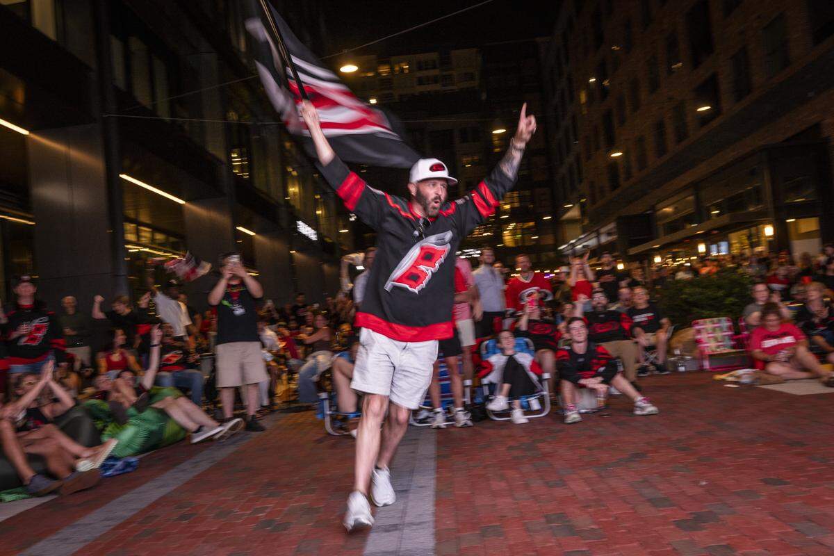 Carolina Hurricanes fans celebrate during an NHL Eastern Conference Final watch party in Raleigh's Smoky Hollow district on Friday, May 29, 2026. 