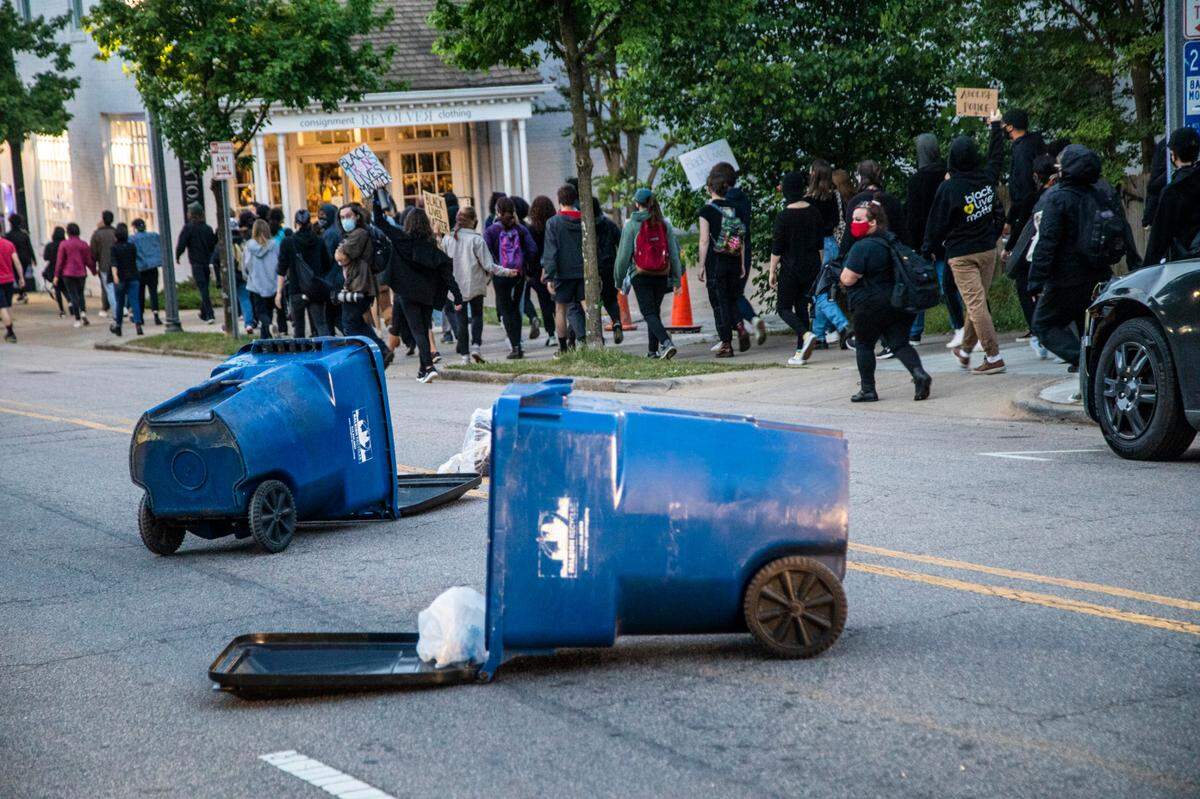 Recyling fans are pulled in to Glenwood Avenue as about 100 protesters marched through downtown Raleigh Friday, April 23, 20121 on the heels of Andrew BrownÕs shooting death in Elizabeth City. Officers called from them to disperse after construction barriers were pulled into the street.