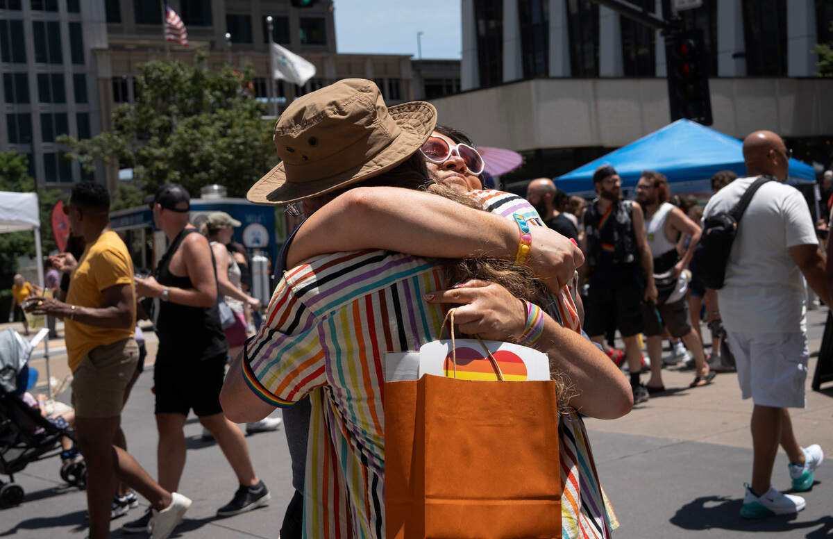 A man gives out “free dad hugs” at the at the Out! Raleigh Pride festival in downtown Raleigh Saturday, June 21, 2025.