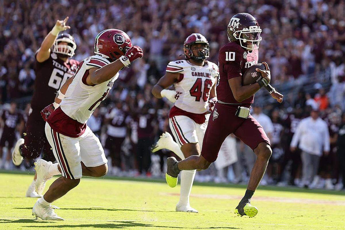 Marcel Reed (10) of the Texas A&M Aggies runs the ball against Justin Okoronkwo (17) of the South Carolina Gamecocks before a flag was thrown to call the play back during the fourth quarter at Kyle Field on Nov. 15, 2025 in College Station, Texas. The Texas A&M Aggies won 31-30.
