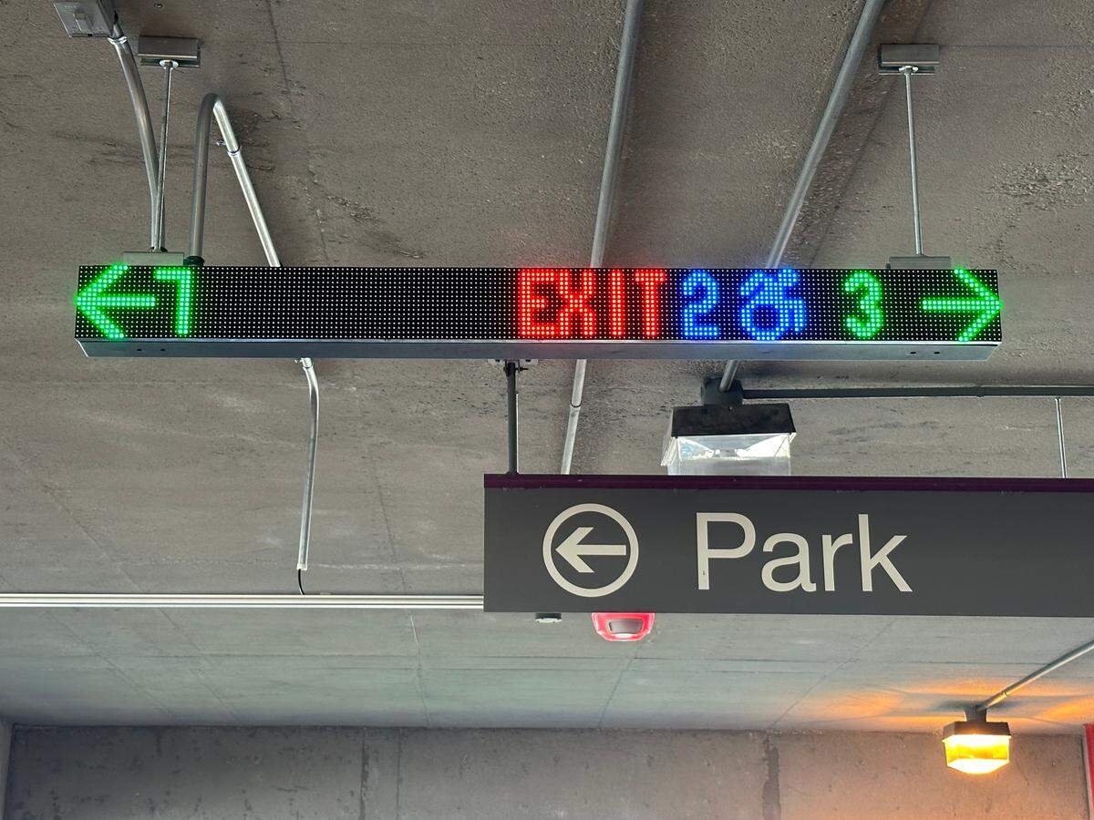 The Park Assist system being tested on one floor of the parking deck at Raleigh-Durham International Airport includes a series of message boards that direct drivers to available spaces. In this case, there are 7 open spaces to the left and 3 to the right, as well as two available handicap spots to the right.