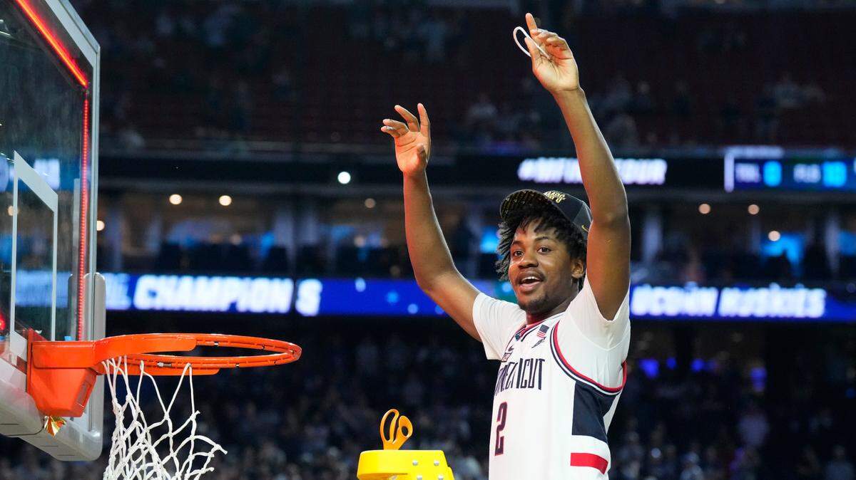 Connecticut Huskies guard Tristen Newton (2) cuts down a piece of the net after defeating the San Diego State Aztecs in the national championship game of the 2023 NCAA Tournament at NRG Stadium.