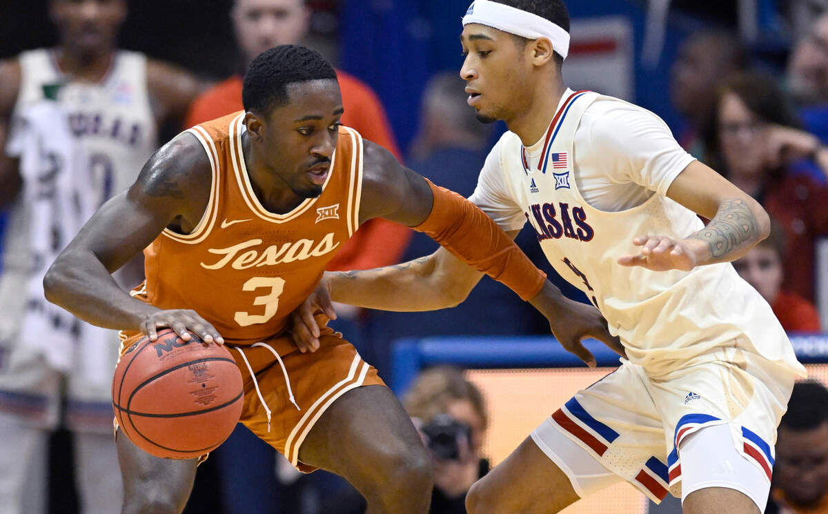 Texas guard Courtney Ramey (3) is guarded by Kansas guard Dajuan Harris Jr., right, during the first half of an NCAA college basketball game in Lawrence, Kan., Saturday, March 5, 2022.
