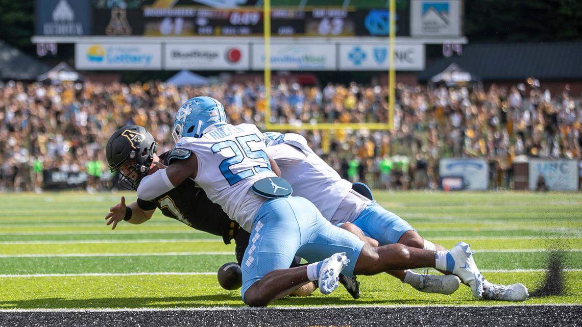 North Carolinas Noah Taylor (7) and Caiman Rucker (25) stop Appalachian State quarterback Chase Brice at the goal line with :09 second to play, preventing a two-point conversion and securing North Carolinas 63-61 victory on Saturday, September 3, 2022 at Kidd Brewer Stadium in Boone, N.C.
