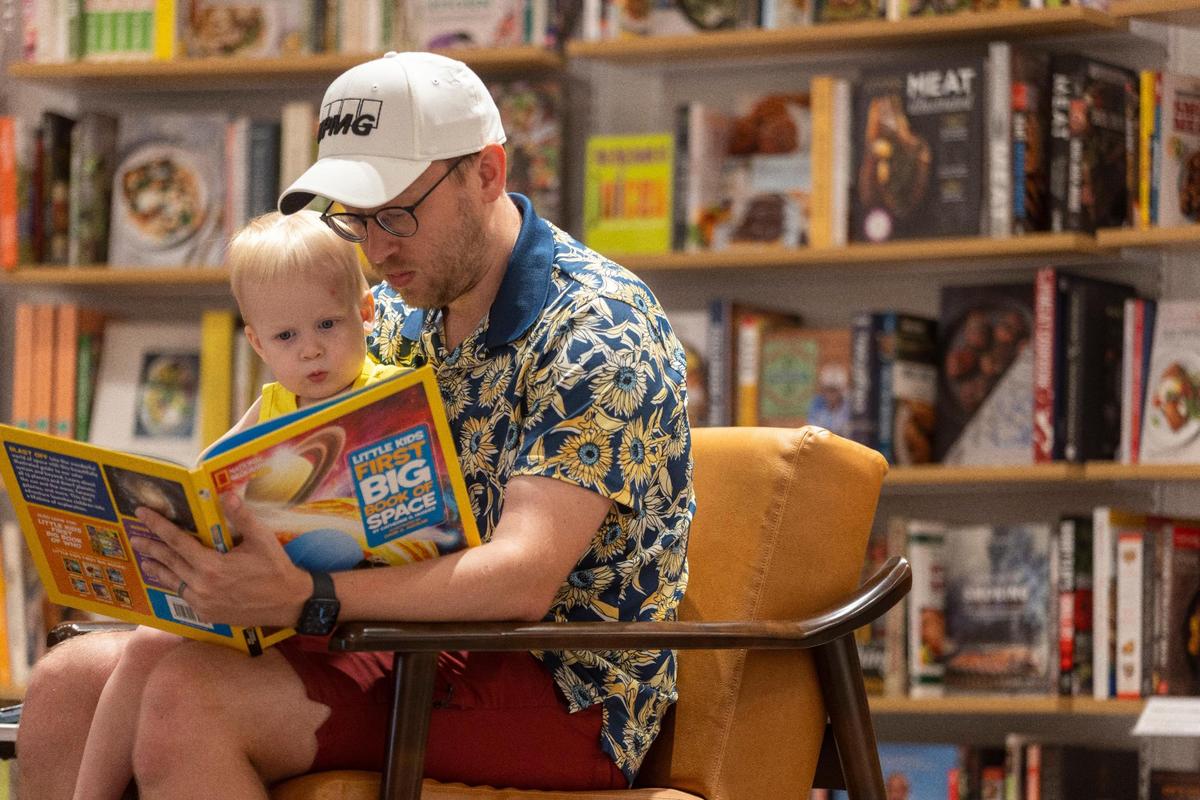 Cory Wills reads to two-year-old Ezra Wills at the new Barnes & Noble store which opened in the Shoppes of Kildare at 1311 Kildaire Farm Road on Wednesday, July 5, 2023 in Cary, N.C