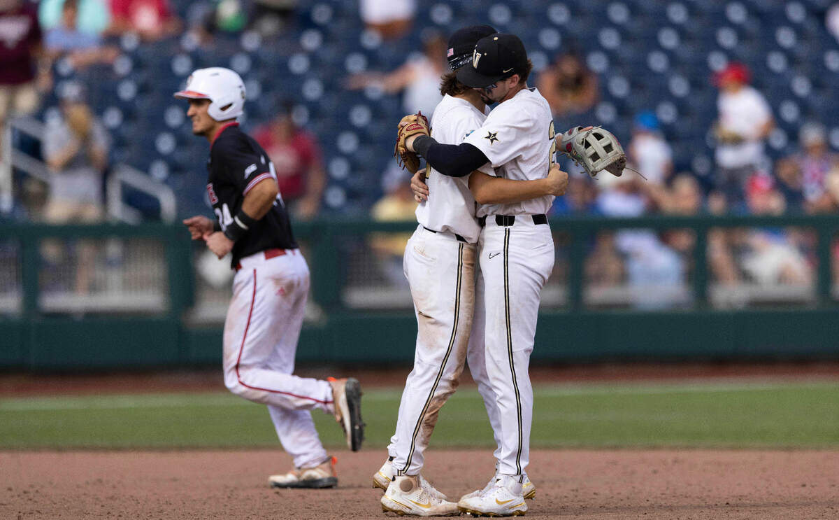 Vanderbilt’s Carter Young, center, hugs Parker Noland following their win over North Carolina State in a baseball game in the College World Series, Friday, June 25, 2021, at TD Ameritrade Park in Omaha.