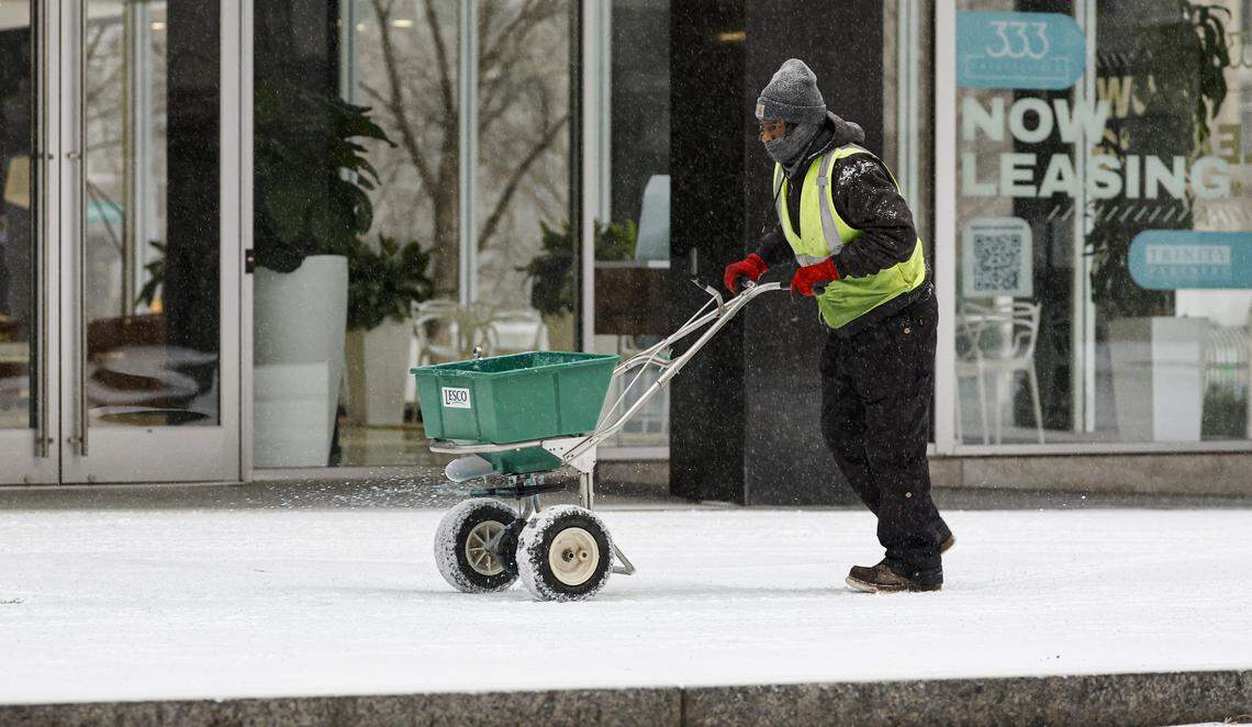 Brandon Chapman with the City of Raleigh Department of Transportation applies ice melt in downtown Raleigh Sunday morning, Jan. 25, 2026. Many businesses across the Triangle are closing or adjusting hours this weekend due to weather.