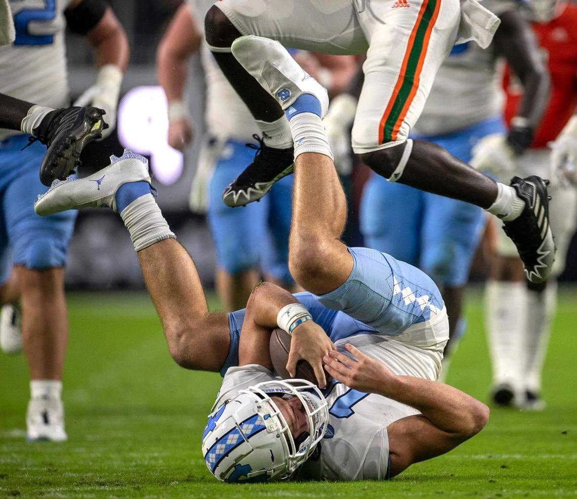 North Carolina quarterback Drake Maye (10) protects the ball after an 11 yards gain in the fourth quarter on Saturday, October 8, 2022 at Hard Rock Stadium in Miami Gardens, Florida. Maye rushed for 53 yards in the Tar Heels’ victory.