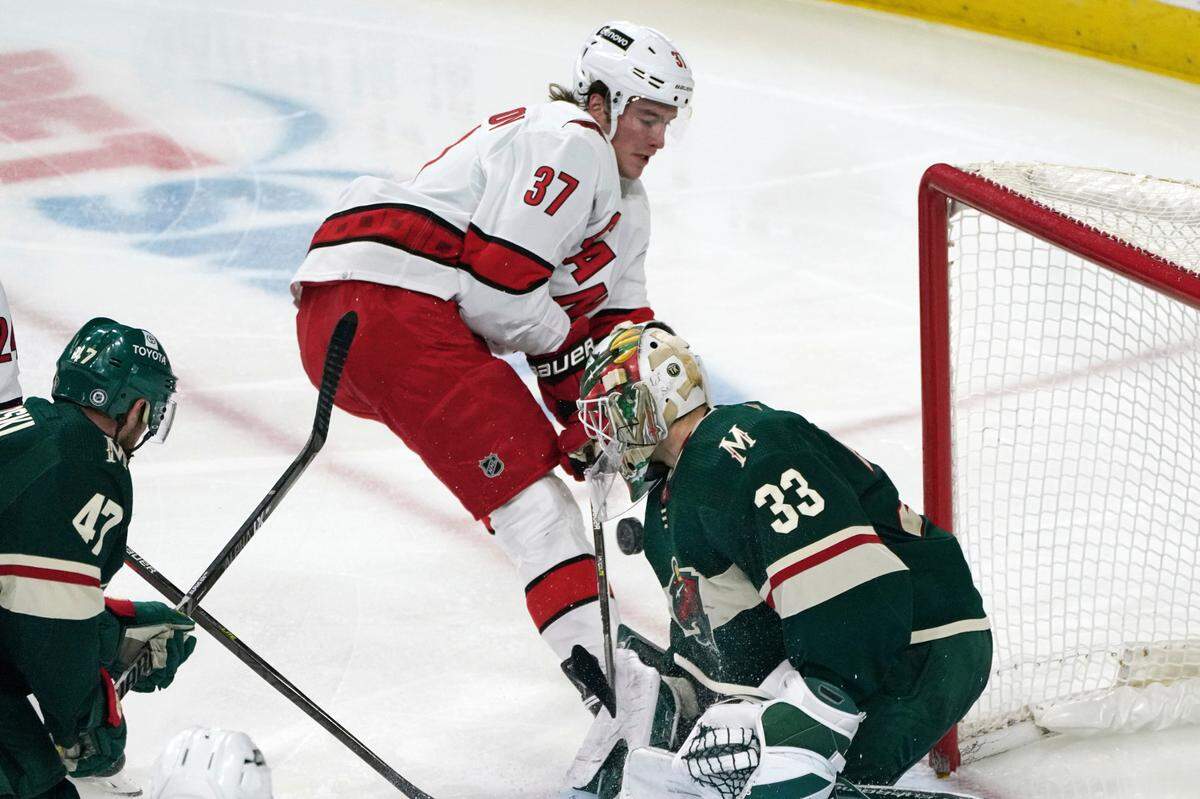 Minnesota Wild goalie Cam Talbot (33) stops a shot by Carolina Hurricanes’ Andrei Svechnikov (37) in the third period of an NHL hockey game, Saturday, Feb. 12, 2022, in St. Paul, Minn. (AP Photo/Jim Mone)