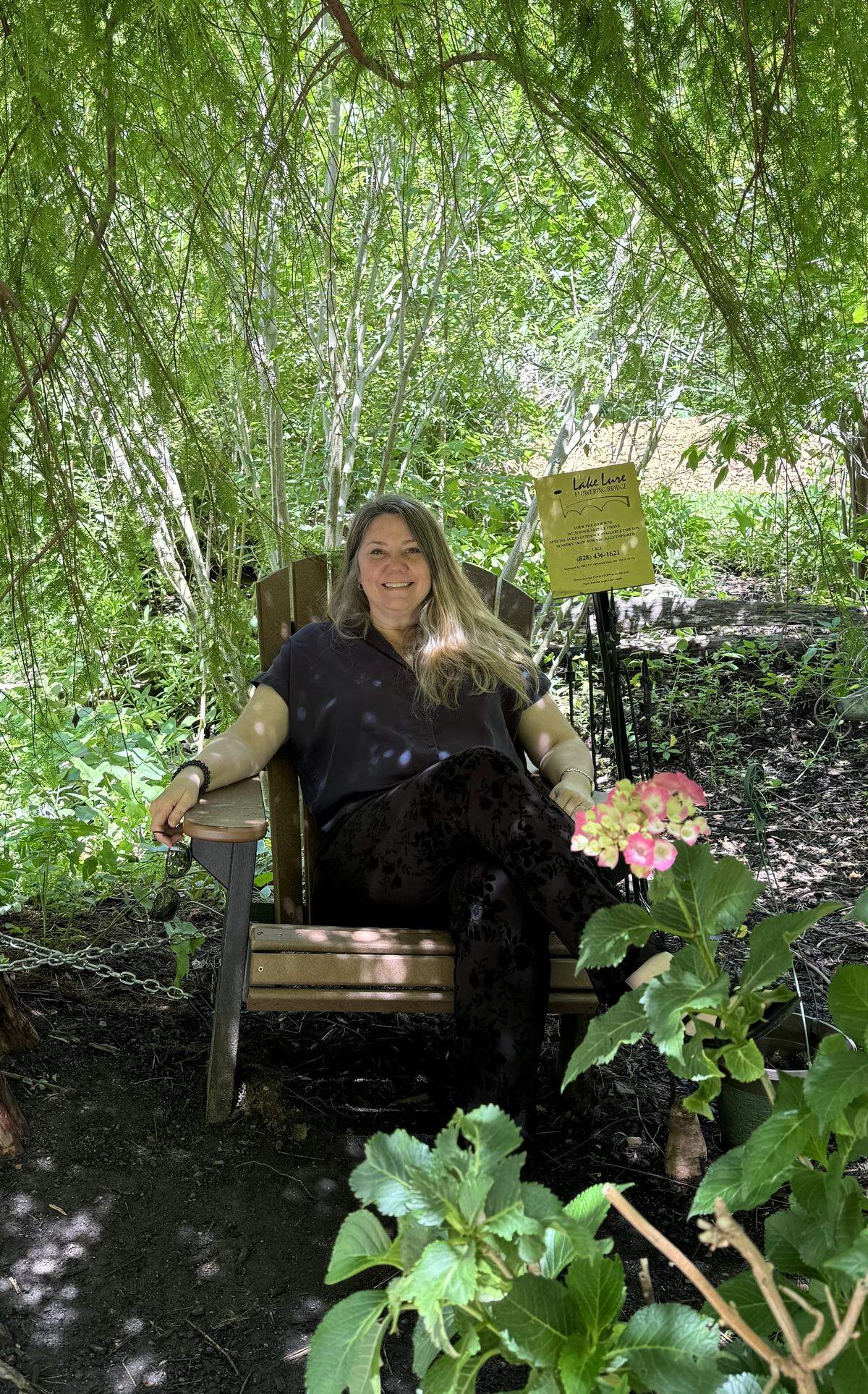 Kris Willing, a regular visitor to Lake Lure Flowering Bridge, relaxes in its shade.