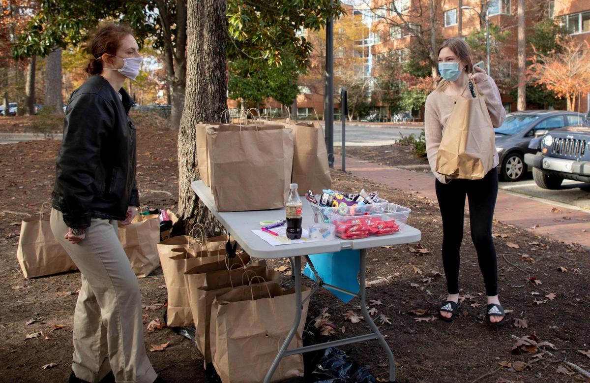 Jenny Deview, right, picks up meals from Jamie Sohn, a member of The Chapel Hill & Carrboro Mothers Club, which is providing free meals to UNC-Chapel Hill students staying on campus over the seven weeks of their extended and isolated winter break during the COVID-19 pandemic, on Wednesday, Dec. 2, 2020, in Chapel Hill, N.C.