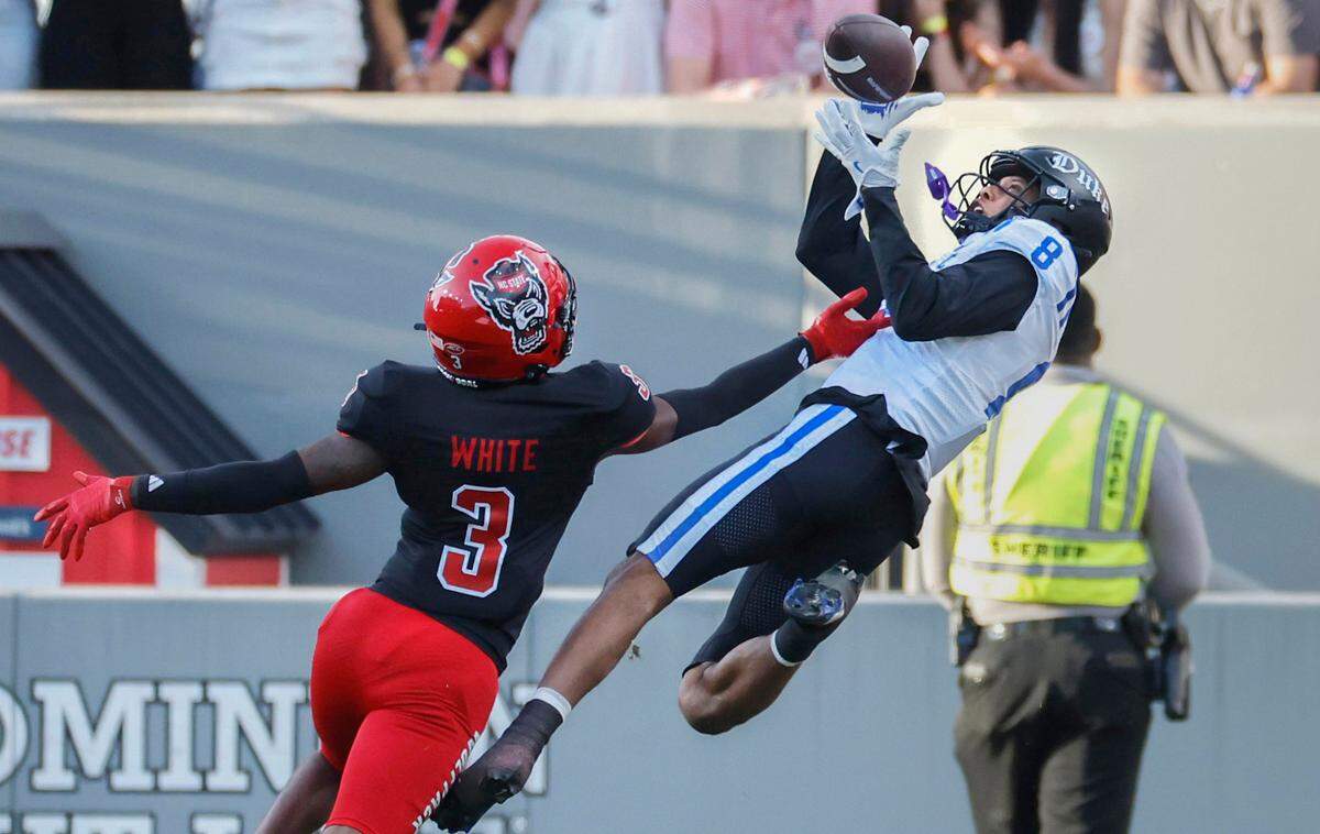 Duke wide receiver Jordan Moore (8) pulls in a 45-yard touchdown reception as N.C. State cornerback Aydan White (3) defends during the first half of N.C. State’s game against Duke at Carter-Finley Stadium in Raleigh, N.C., Sat. Nov. 9, 2024.