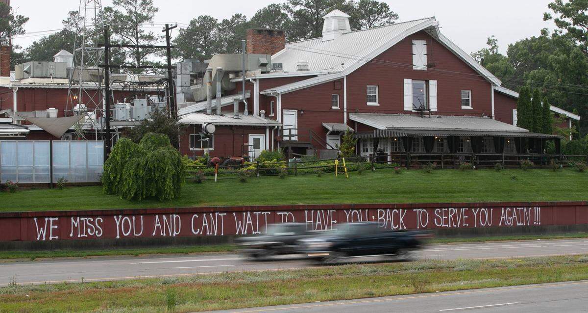 Angus Barn owner Van Eure has painted a welcoming message on the front of her restaurant on Glenwood Ave. on Tuesday, May 19, 2020 in Raleigh, N.C. Eure and her staff are preparing to open their dining rooms in anticipation of Gov. Roy Cooper lifting his coronavirus restrictions.