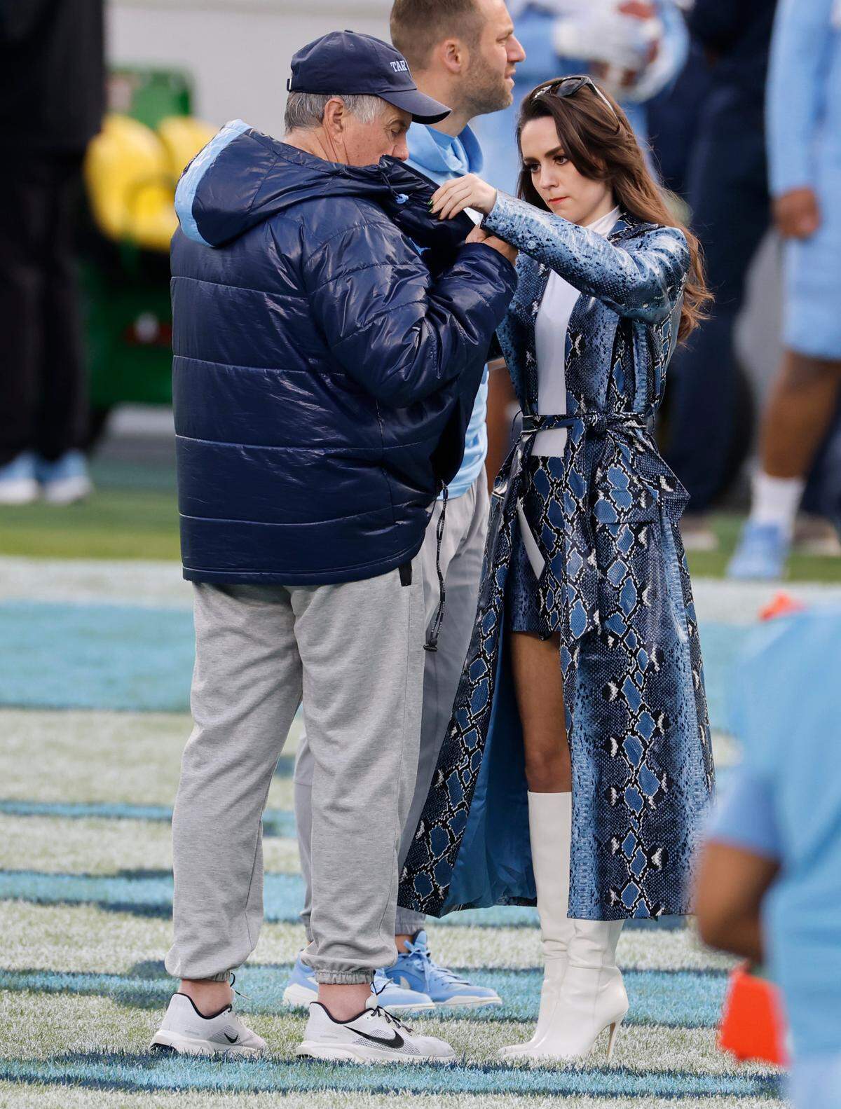 Jordon Hudson helps North Carolina head football coach Bill Belichick put on a mic before UNC football’s Practice Like a Pro open practice at Kenan Stadium in Chapel Hill, N.C., Saturday, April 12, 2025.