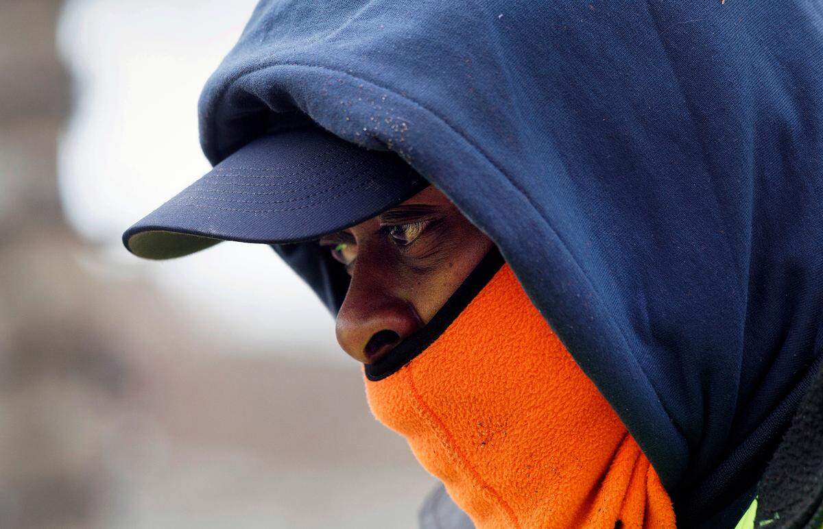 Travis Bittle, a city of Durham employee, bundles up while working to clear debris from a downtown plaza as temperatures hover in the mid-20s on Tuesday, Jan. 21, 2025.