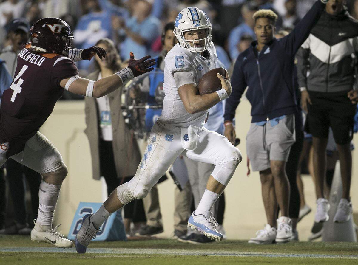 North Carolina quarterback Cade Fortin (6) rushes for 40 yards in the first quarter before being stopped by  Virginia Tech’s Quincy Patterson II (4) on Saturday, October 13, 2018 at Kenan Stadium in Chapel Hill, N.C.
