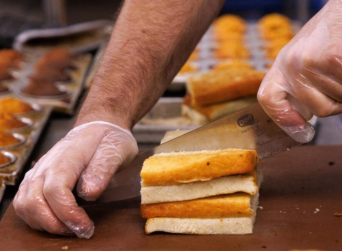 Adam Bauer, kitchen manager at Sam Jones BBQ, slices cornbread at the restaurant on Wednesday, June 5, 2024, in Raleigh, N.C.