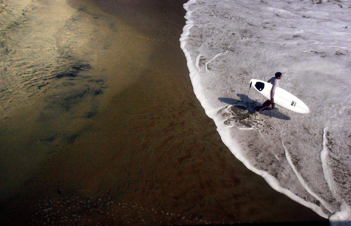 A surfer enters the Atlantic during an afternoon of prime surfing conditions in Rodanthe, N.C. in Sept. 2003.