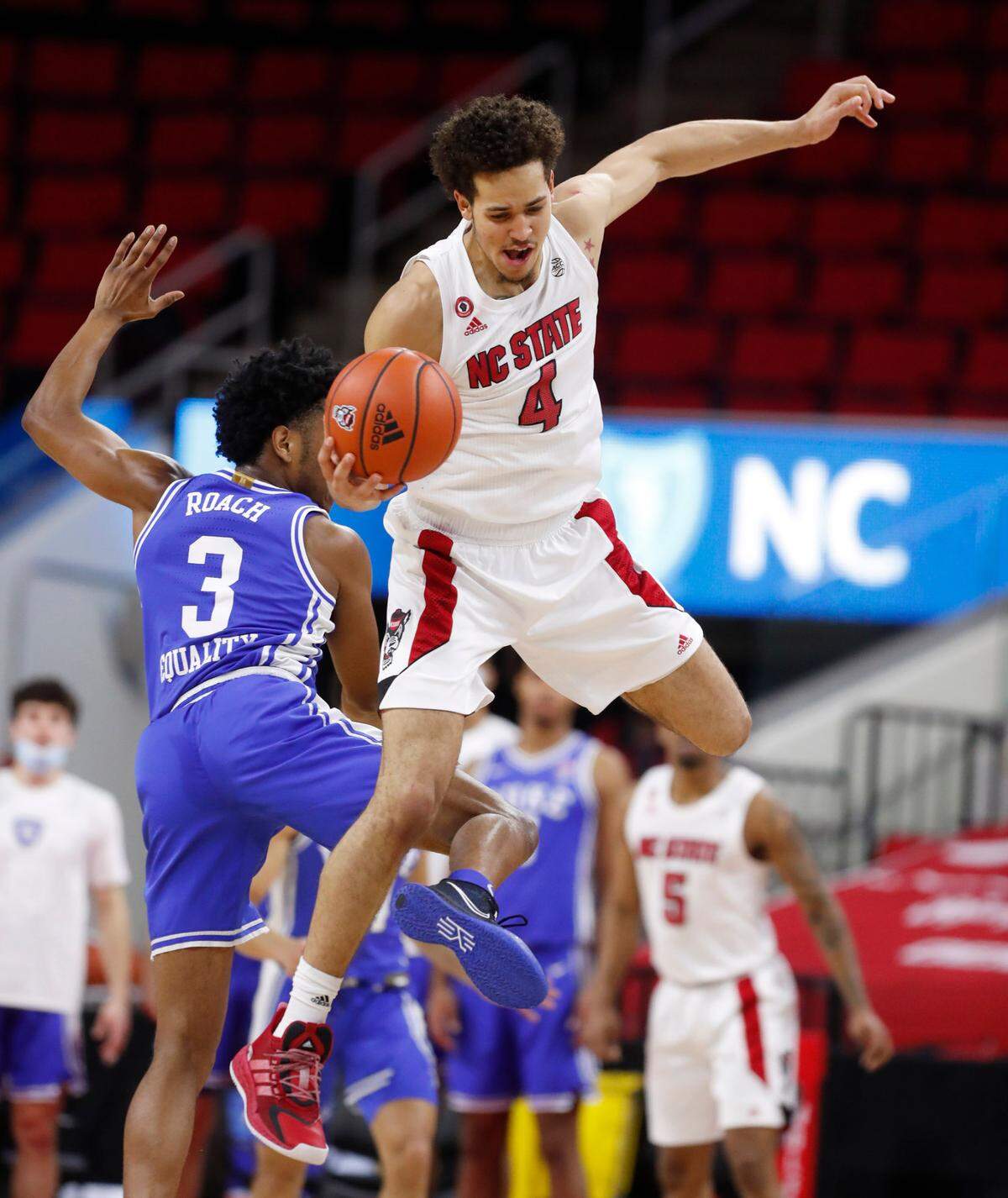 N.C. State’s Jericole Hellems (4) pulls in the ball in front of Duke’s Jeremy Roach (3) during the first half of N.C. State’s game against Duke at PNC Arena in Raleigh, N.C., Saturday, February 13, 2021.