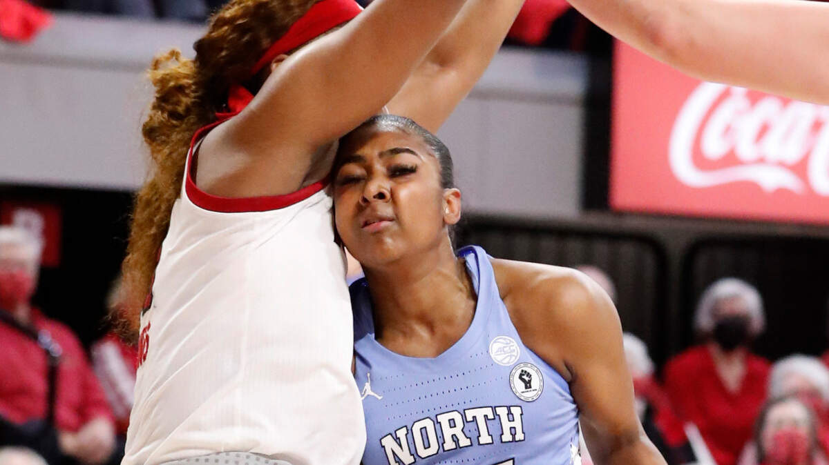 North Carolina’s Deja Kelly (25) drives to the basket while defended by N.C. State’s Kayla Jones (25) during the first half of N.C. State’s game against UNC at Reynolds Coliseum in Raleigh, N.C., Thursday, January 6, 2022.