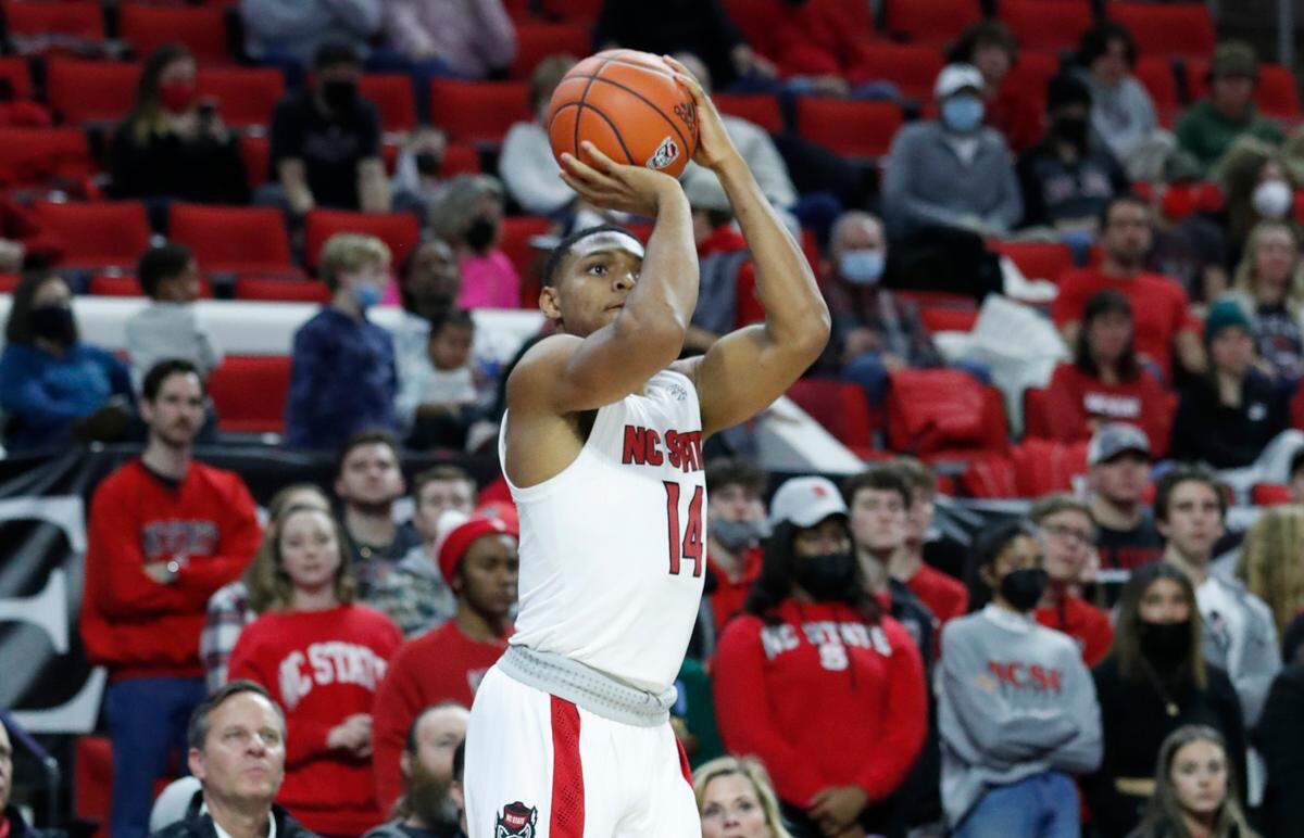 N.C. State’s Casey Morsell (14) shoots a three-pointer during the second half of N.C. State’s 77-63 victory over Virginia at PNC Arena in Raleigh, N.C., Saturday, Jan. 22, 2022.