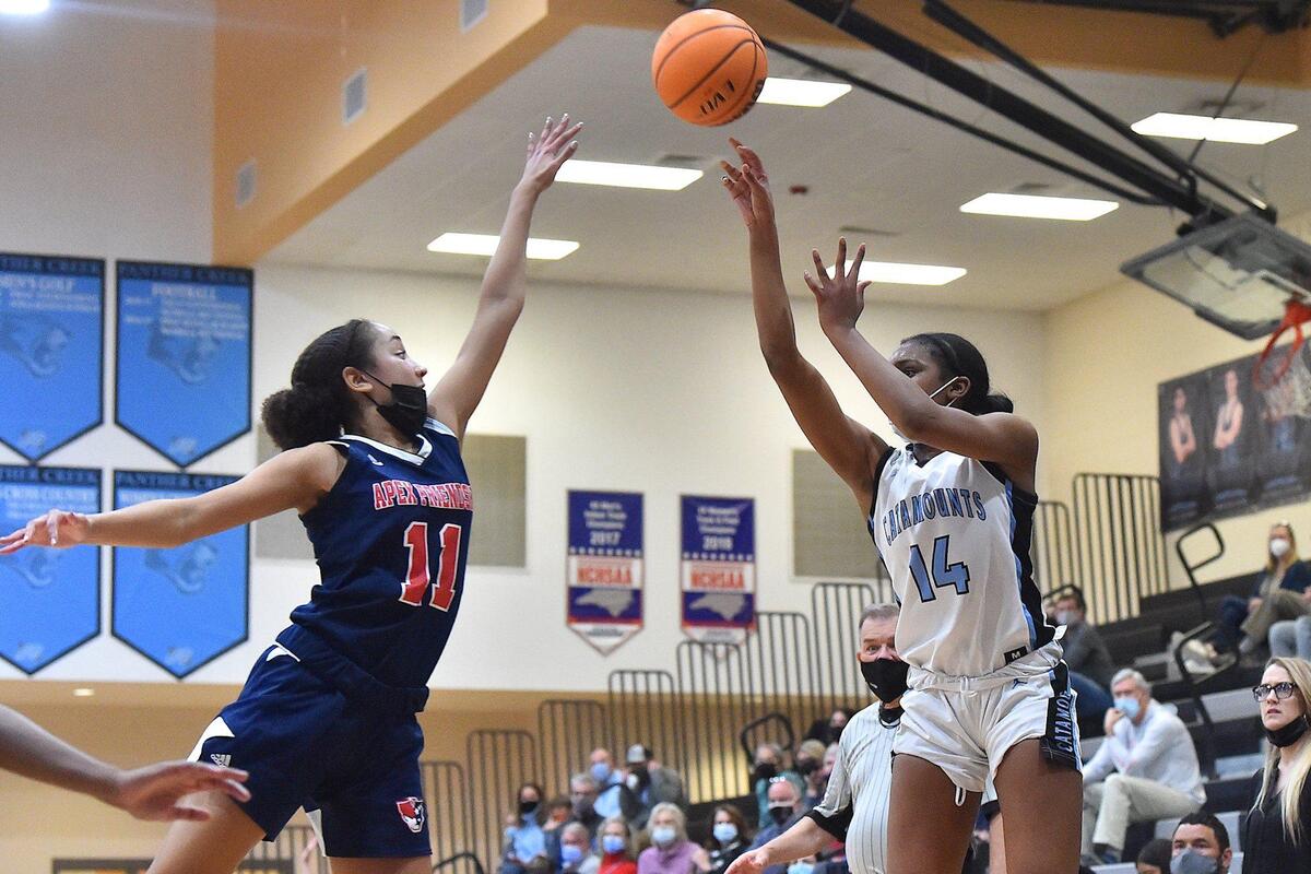 Panther Creek’s Madisyn Jordan (14) launches the jump shot over Apex Friendship’s Victoria Sagne (11) . The Panther Creek Catamounts and the Apex Friendship Patriots met in a conference basketball game in Cary, NC on January 28, 2022.