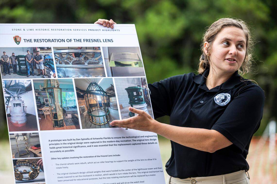 Cape Hatteras Lighthouse restoration project manager, Lindsey Gravel, show photographs of the lighthouse’s Fresnel lens restoration during a tour of the restoration project on Monday, July 1, 2024. The project is expected to cost $19.2 million and will include replacing 40,000 of its estimated 1,250,000 bricks, replacing rusted or broken metal components and the installation of a near-exact replica of the first-order Fresnel lens.