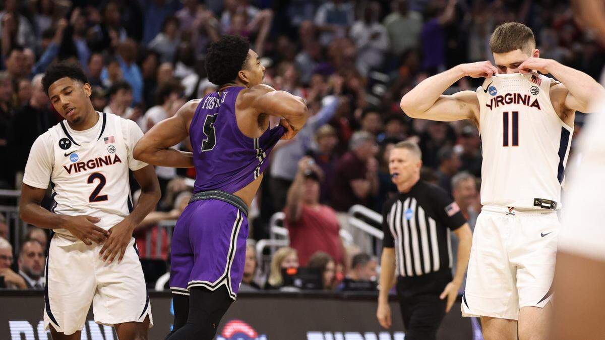 Furman Paladins guard Marcus Foster (5) celebrates as Virginia Cavaliers guard Reece Beekman (2) and guard Isaac McKneely (11) react after the game at Amway Center.
