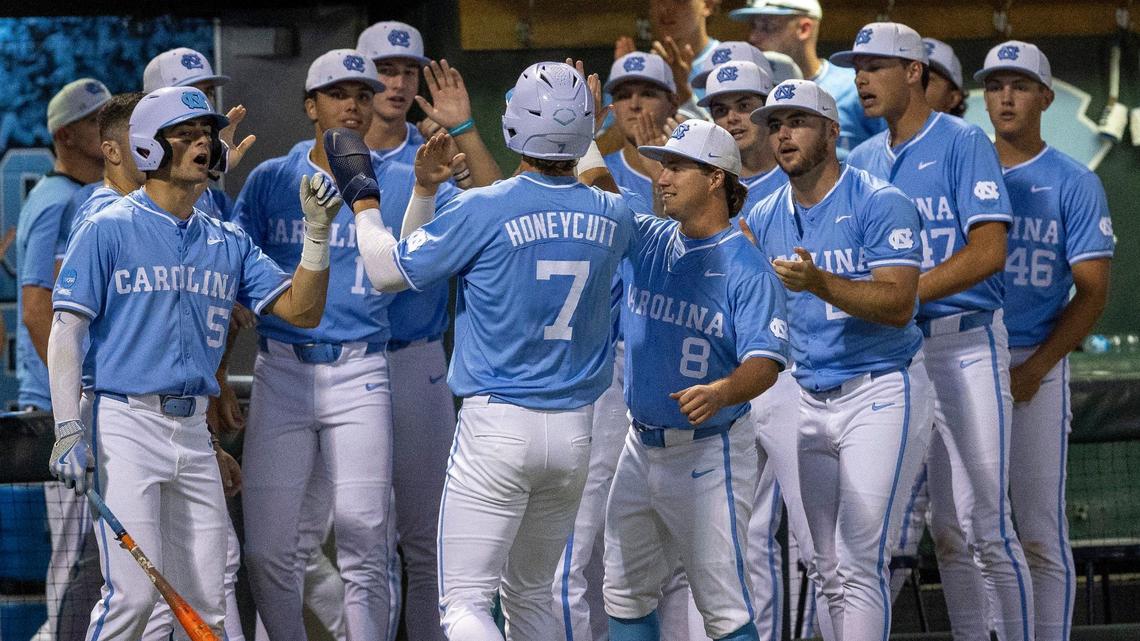 North Carolina’s Vance Honeycutt (7) greeted by his teammates after scoring on an RBI by Parks Harber to take a 2-0 lead in the third inning against West Virginia during the NCAA Super Regional on Saturday, June 8, 2024 at Boshamer Stadium in Chapel Hill, N.C.