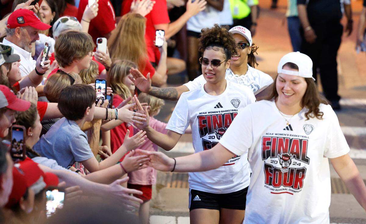 Fans greet women’s basketball players including N.C. State’s Madison Hayes, center, as they walk to the belltower during a celebration for the N.C. State men’s and women’s basketball team at the Memorial Belltower in Raleigh, N.C., Monday, April 15, 2024. Both teams made it to the NCAA Tournament Final Four and the men’s team won the ACC Championship by winning five games in five days.