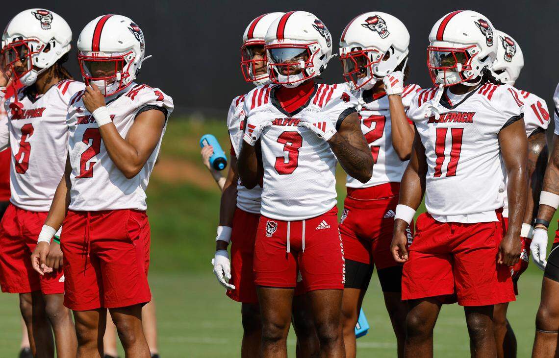 From left, N.C. State’s Brandon Cisse (2), Aydan White (3) and Ja’Had Carter (11) watch a drill during the Wolfpack’s first practice in Raleigh, N.C., Wednesday, July 31, 2024.