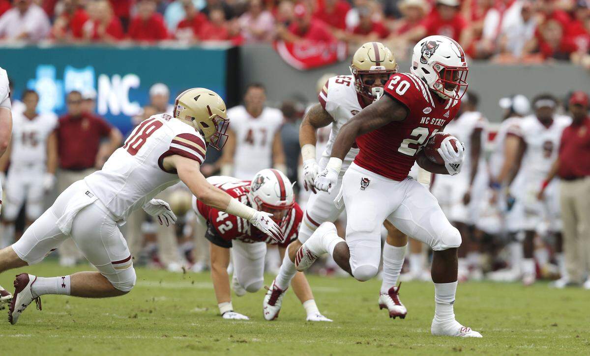 N.C. State’s Ricky Person (20) gains yards as Boston College’s Mike Palmer (18) tries to tackle him during the first half of N.C. State’s game against Boston College at Carter-Finley Stadium in Raleigh, N.C., Saturday, Oct. 6, 2018.