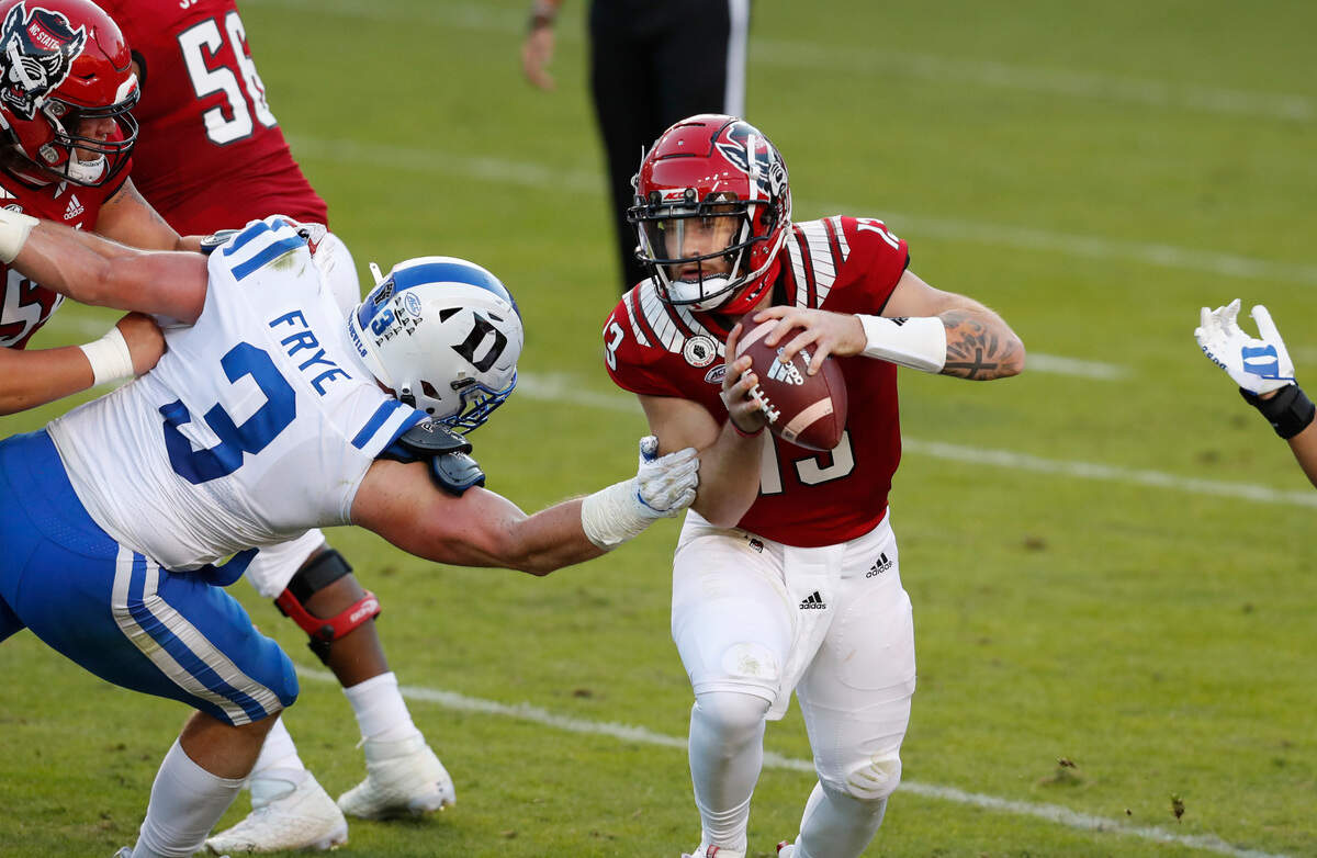 N.C. State quarterback Devin Leary (13) avoids the pressure by Duke’s Ben Frye during the second half of N.C. State’s 31-20 victory over Duke at Carter-Finley Stadium in Raleigh, N.C., Saturday, Oct. 17, 2020.