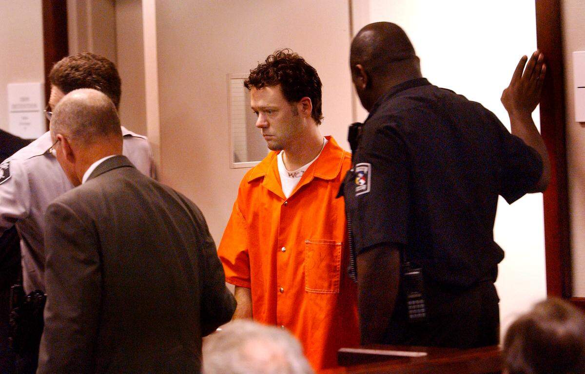 Larry Veeder is led into a courtroom inside the Wake County Detention Center Nov. 3, 2003 for his first appeared before a Wake District Court judge on charges related to the wreck along N.C. 54 that took the lives of six people. Veeder, 32, was charged with driving while impaired and six counts of involuntary manslaughter for the crash that killed six people who had stopped to help other motorists involved  in an earlier wreck at N.C. 54 and Nowell Road.  Shortly before his first court appearance, Veeder was  escorted into a private room to talk to Raleigh lawyer Rick Gammon. After a brief consultation, Veeder, now clad in an orange jumpsuit and flip flops, stood before District Court Judge Anne Salisbury in a courtroom inside the Wake County Detention Center.   