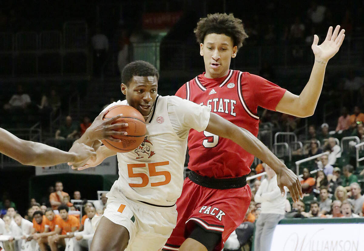 UM Hurricanes Wooga Poplar (55) makes his way past N.C. State’s Jack Clark (5) during their game on Saturday, December 10, 2022 at Watsco Center in Coral Gables.