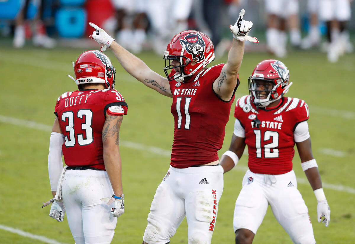 N.C. State’s Payton Wilson (11) and Devan Boykin (12) celebrate with Isaac Duffy (33) after Duffy broke up a pass during the second half of N.C. State’s 31-20 victory over Duke at Carter-Finley Stadium in Raleigh, N.C., Saturday, Oct. 17, 2020.