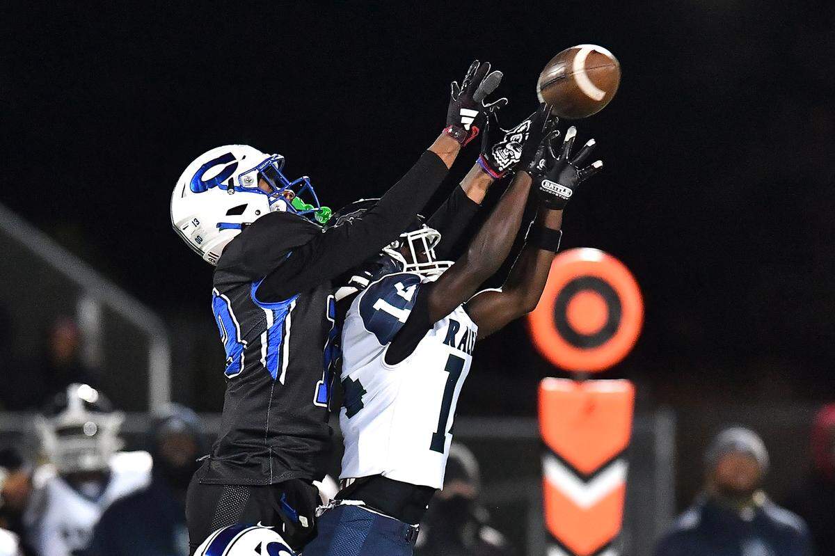 Southeast Raleigh wide receiver Cam Bullock (14) attempts to catch the pass against Clayton's Akedran Crumel (13) during the second half. The Clayton Comets and the Southeast Raleigh Bulldogs met in the fourth round of the NCHSAA 7A Playoffs in Clayton, N.C. on November 28, 2025.