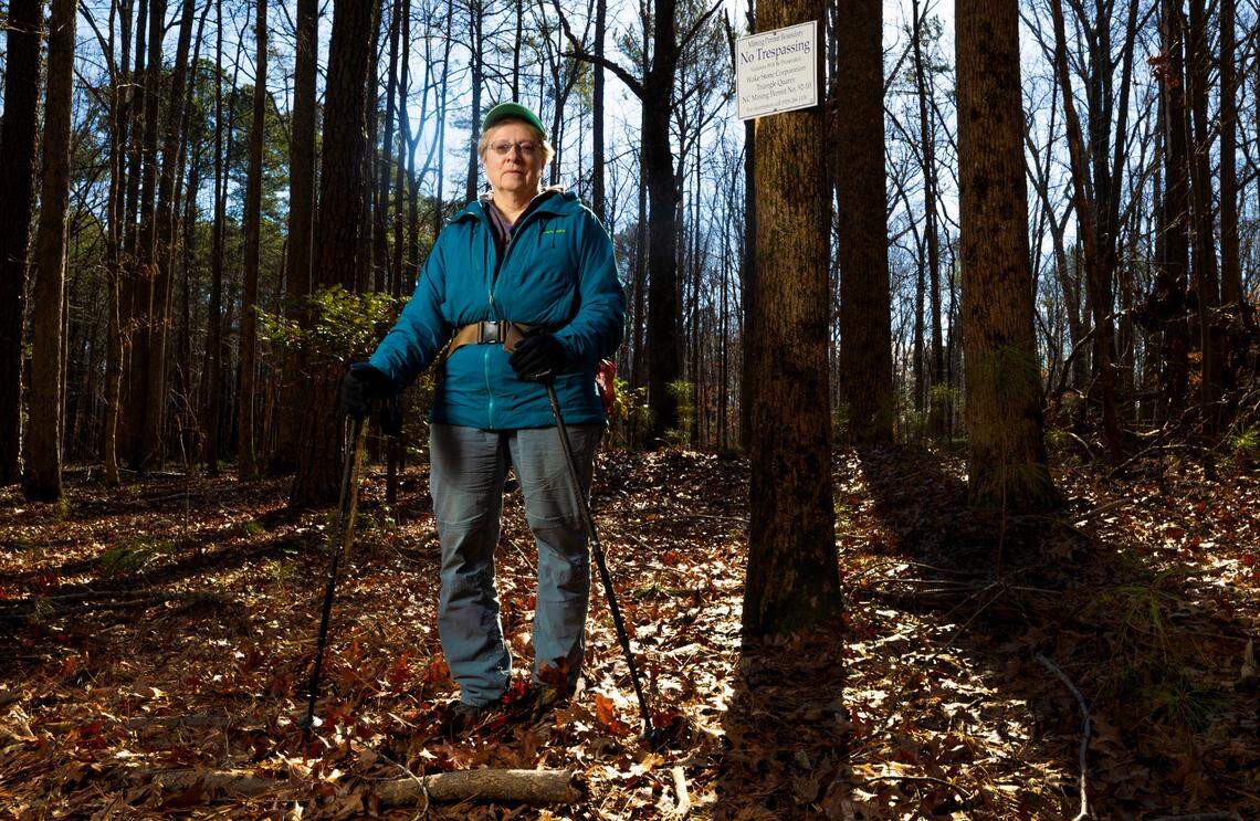 Jean Spooner poses Jan. 11, 2024, in William B. Umstead State Park near Cary, next to land owned by Raleigh-Durham International Airport. Wake Stone Corp. has a mineral lease on the RDU land and plans to build a stone quarry there.