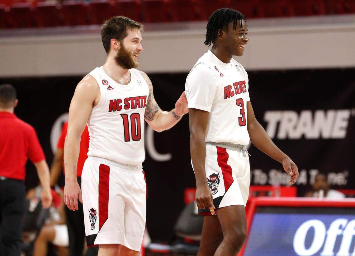 N.C. State’s Braxton Beverly (10) laughs with Cam Hayes (3) during N.C. State’s game against Charleston Southern in the Wolfpack Invitational at Reynolds Coliseum in Raleigh, N.C., Wednesday, Nov. 25, 2020.