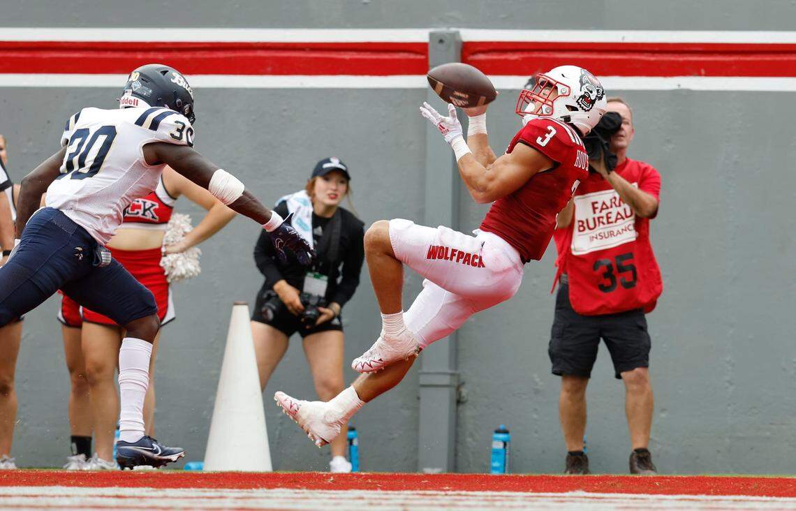 N.C. States Jordan Houston (3) pulls in a 24-yard touchdown reception during the first half of N.C. States game against Charleston Southern at Carter-Finley Stadium in Raleigh, N.C., Saturday, Sept. 10, 2022. Charleston Southern linebacker Shary Jefferson (30) defends.