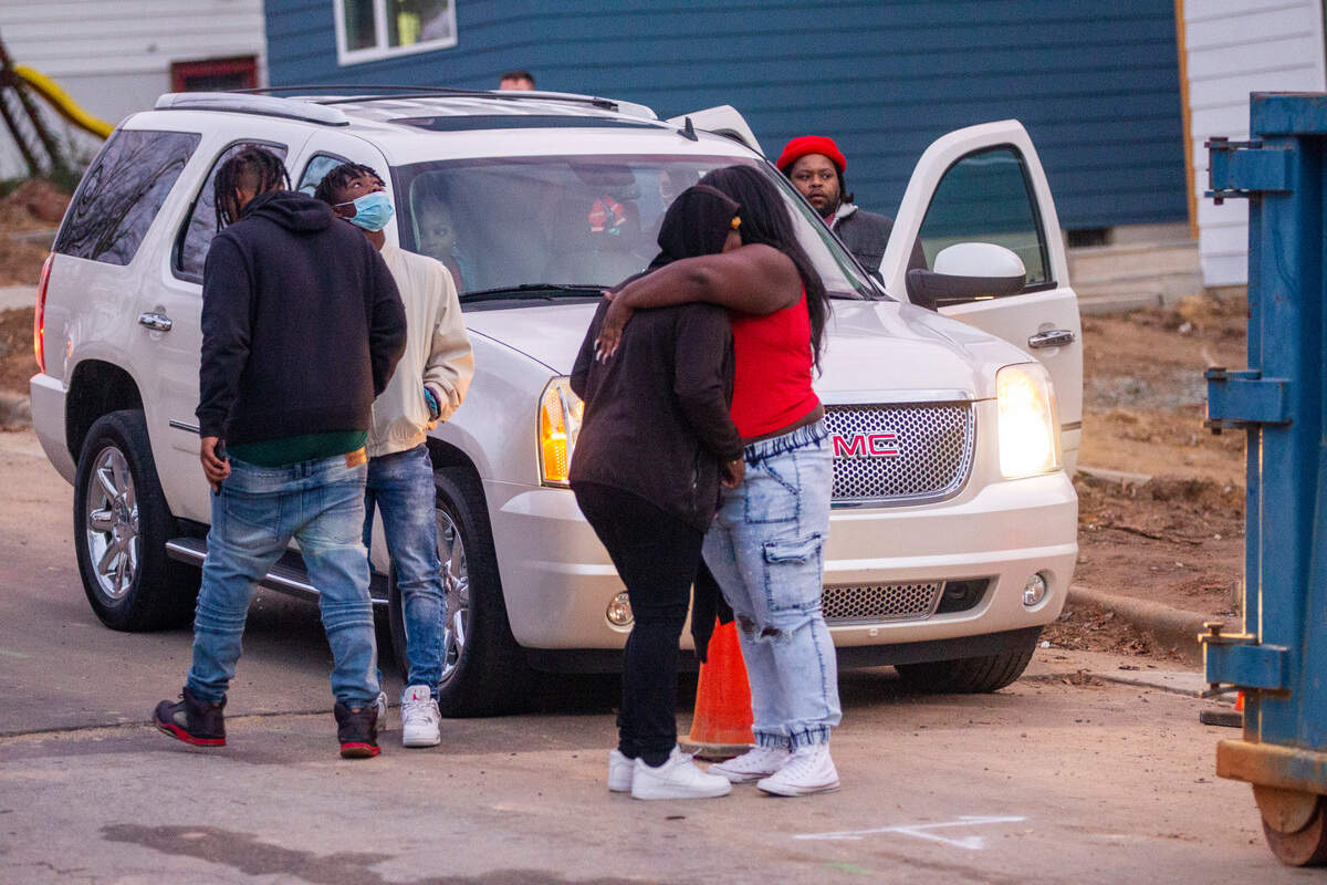Mourners console each other after a balloon release Thursday, Dec. 16, 2021 in Durham at the site of a Monday morning shooting that left two teenagers dead and four other children injured.