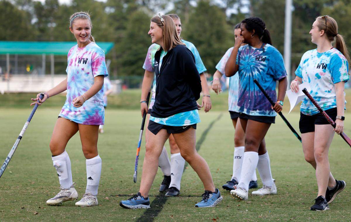 Whitford Wooten talks with Anna Stone during warmups before their game with St. Mary’s School Tuesday, Oct. 10, 2023. Wooten, an assistant field hockey coach at Ravenscroft High School, has ALS (amyotrophic lateral sclerosis or Lou Gehrig’s disease), a progressive neurodegenerative disease.